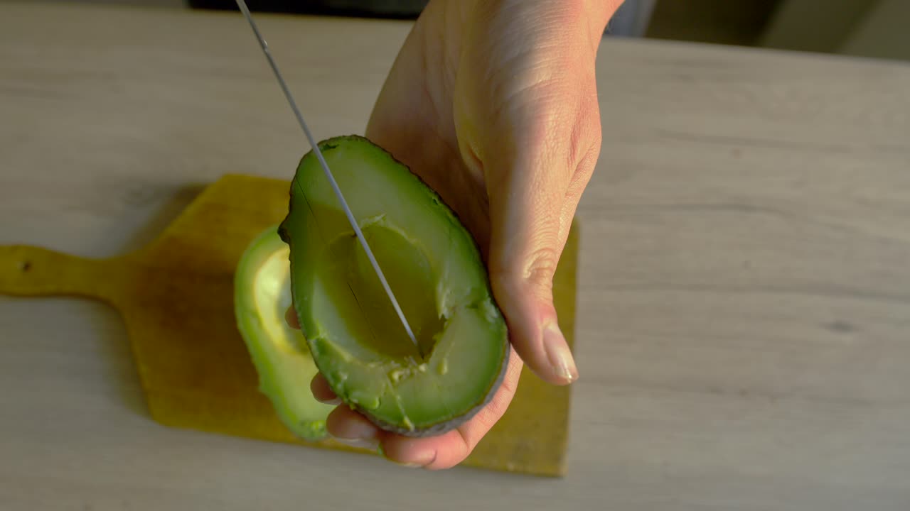 Una donna che taglia l'avocado al rallentatore