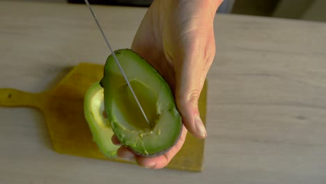 Female-cutting-avocado-in-slow-motion