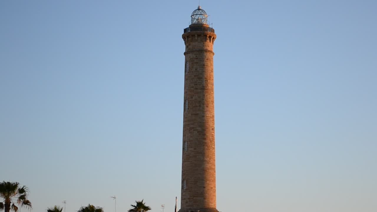 Faro bellissimo. Luce dorata sul faro di Chipiona e sulla spiaggia a Cadice, Spagna, al tramonto.