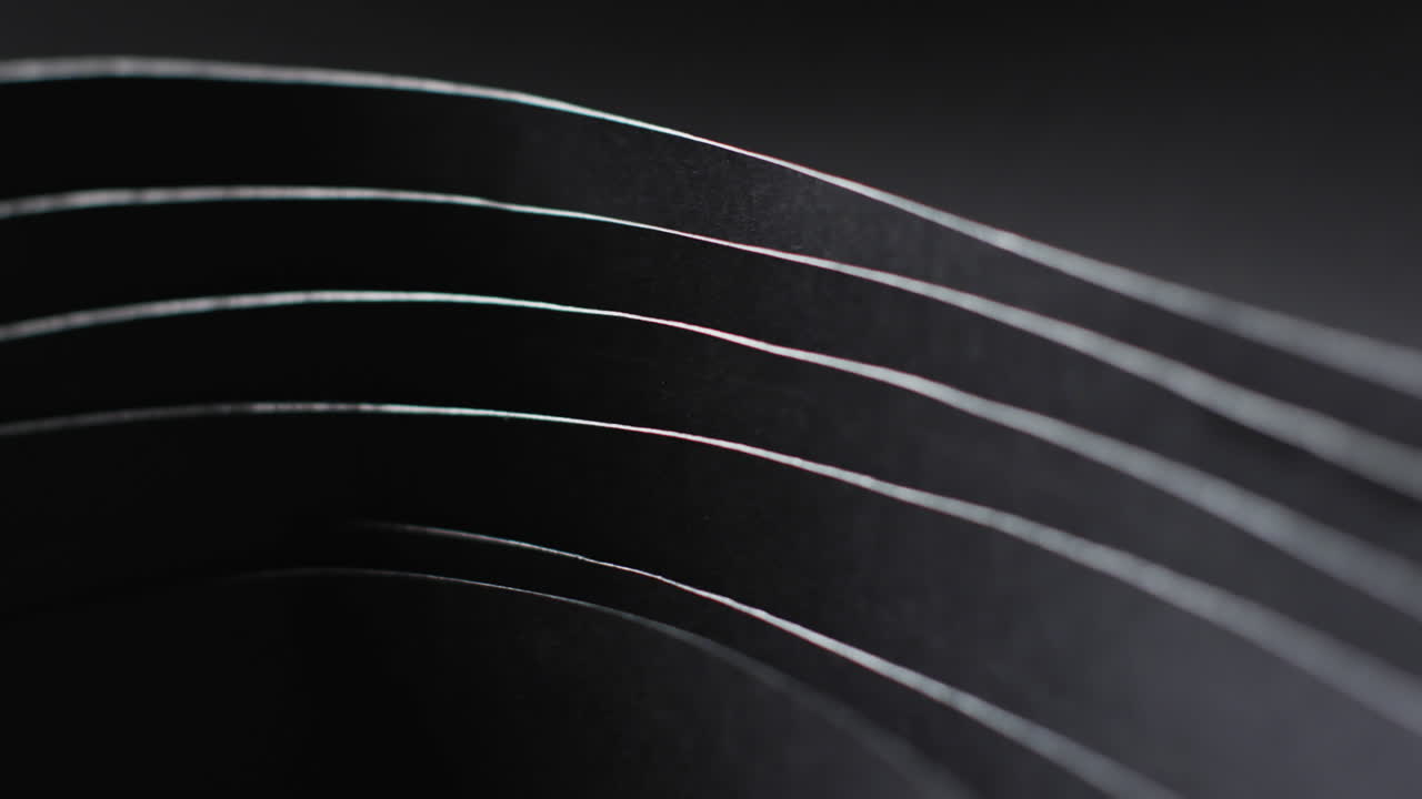 검은색 바탕에 있는 검은색 종이 층과 복사 공간의 클로즈업 비디오