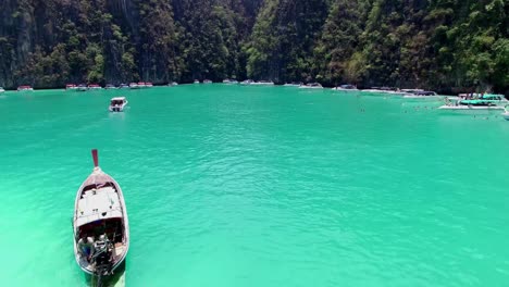 tourist people swimming and snorkeling in crystal clear water at maya bay, phi phi leh island