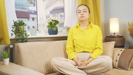 the young woman in front of the window, taking a deep breath and closing her eyes.