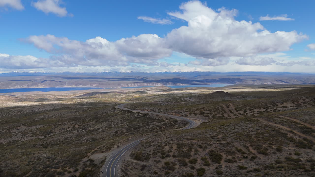 Stunning pedestal shot of the Embalse Piedra del Aguila and Andes mountain range, cloudy blue sky, copy space