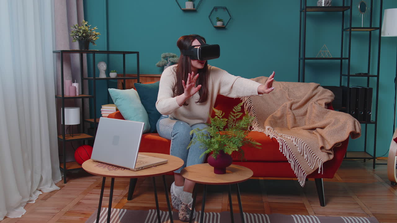 niña joven usa gafas de realidad virtual en casa juega videojuegos en 3d haciendo gestos con las manos