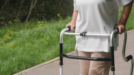 mujer anciana usando un andador en el parque