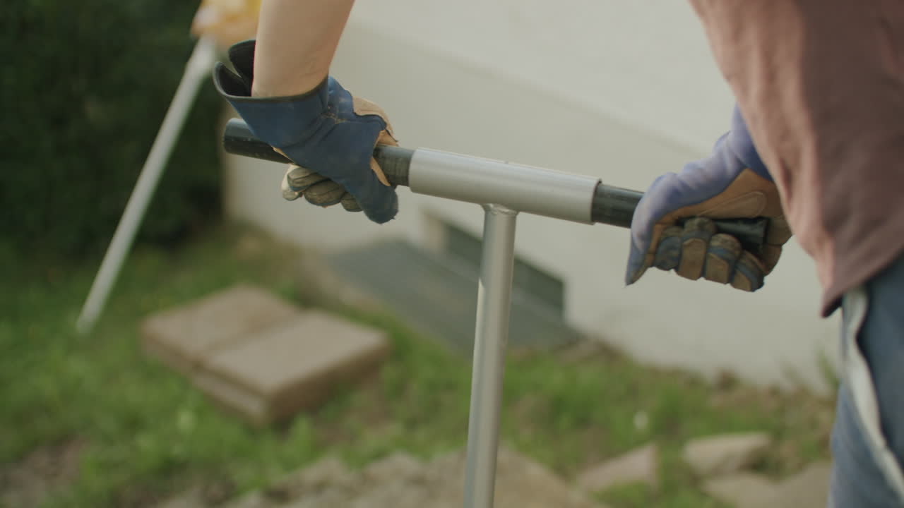 Person using a manual auger to dig a hole in the ground