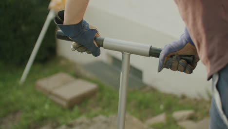 person using a manual auger to dig a hole in the ground