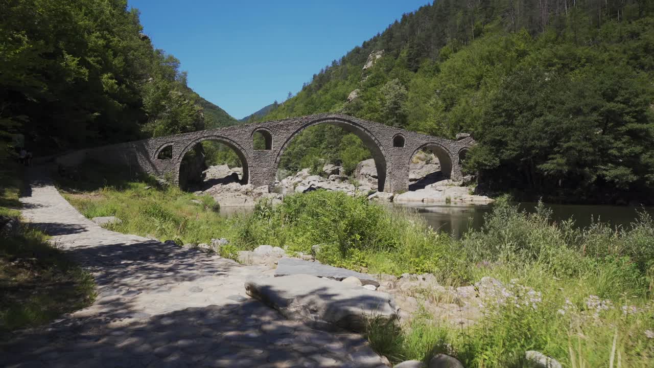 Approaching shot of the picturesque landscape of Arda River and the historical Devil's Bridge right next to the Rhodope Mountains, in Ardino, Bulgaria