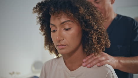 doctor examine patient neck in clinic closeup. woman client turn head