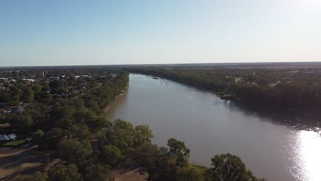 Vista-Aérea-De-Un-Río-En-Australia-Que-Muestra-Un-Pequeño-Pueblo-En-El-Lado-Izquierdo-Y-Un-Gran-Bullicio-En-El-Derecho.