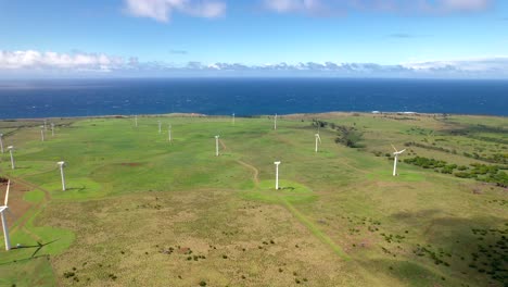 aerial view of wind farm with spinning turbines in hawaii on sunny day