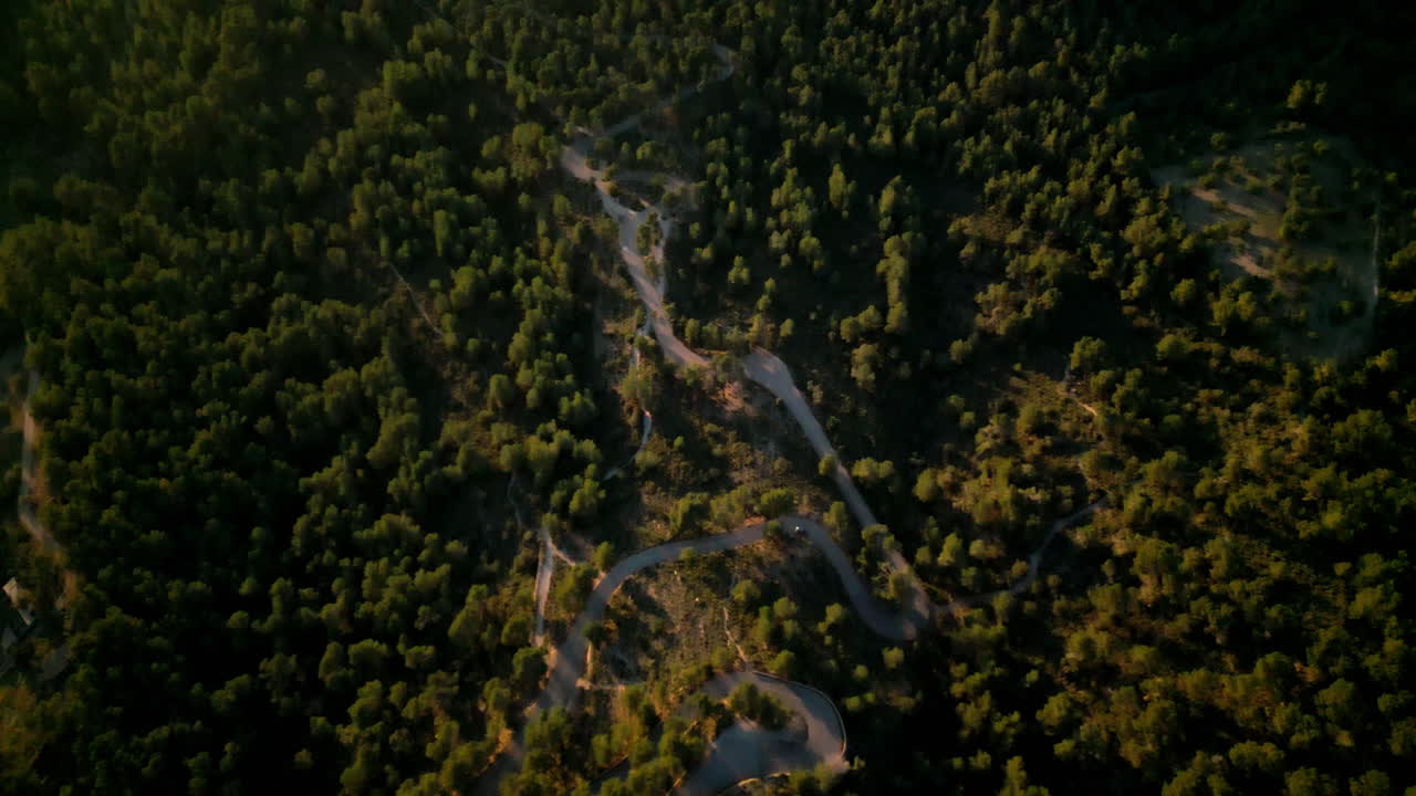 vista aérea de carreteras sinuosas a través de los densos bosques de sant salvador, mallorca