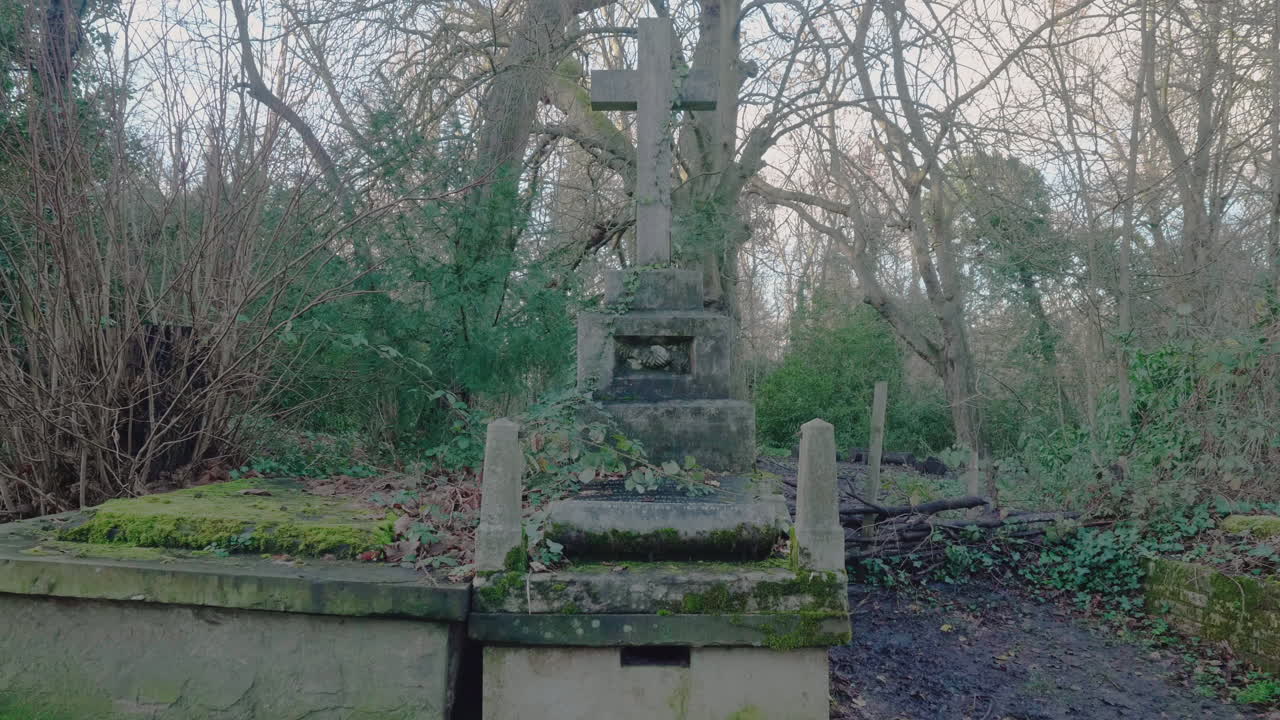 Dolly backwards shot of an old mossy grave on an old English cemetery.