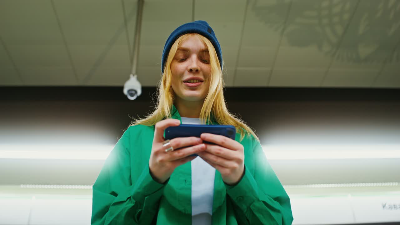 Kvinde bruger telefon i en undergrundsstation