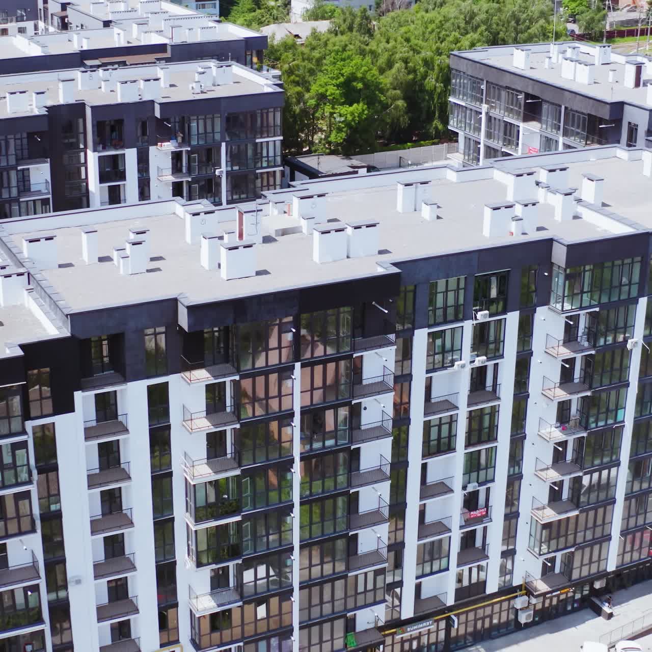 Modern apartment buildings in the city. New residential complex with high-raised buildings of modern design. Roofs of multi-storey buildings on urban background. Aerial view