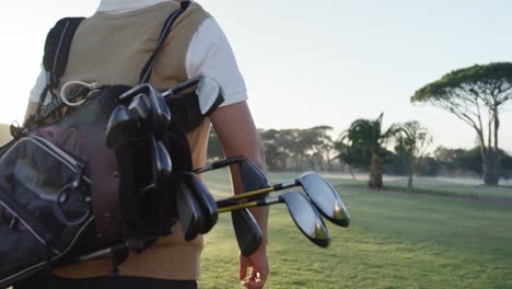 golfer carrying his golf bag