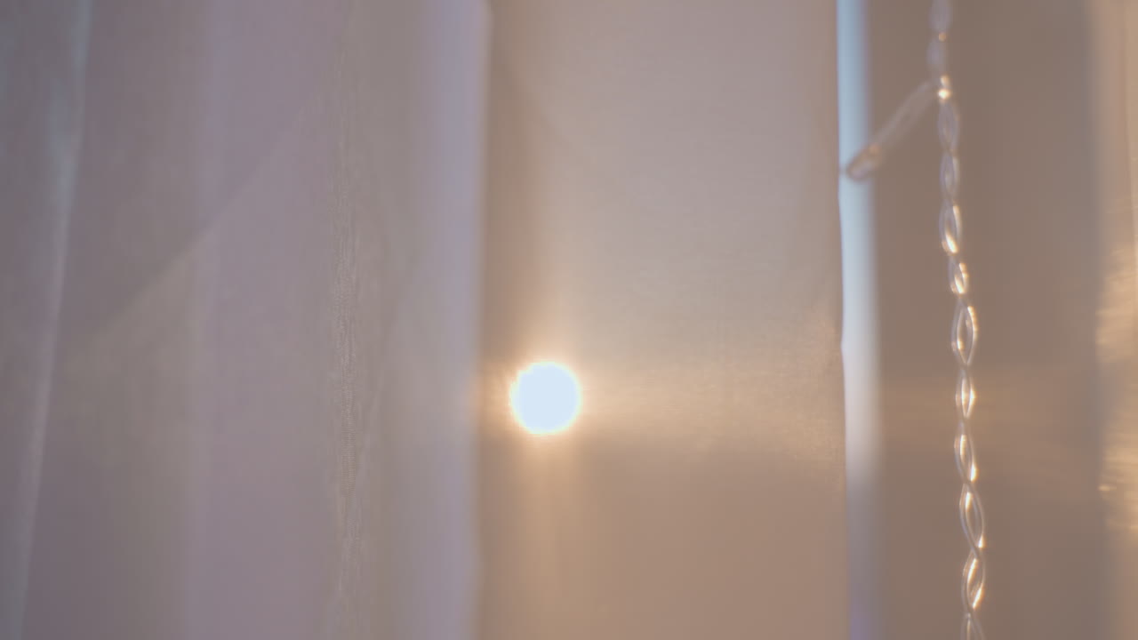 Sunlight Peeking Through Sheer Curtain, Casting Warm Glow Across Metal Chain And Soft Haze, Slow Drifting Dust Particles, Intimate Dawn Atmosphere, Minimal Composition, Dreamy Bokeh