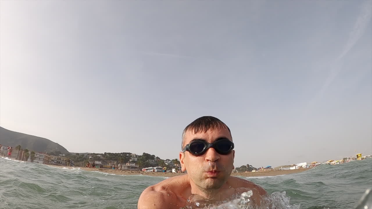 Man wearing swimming googles swimming in the sea