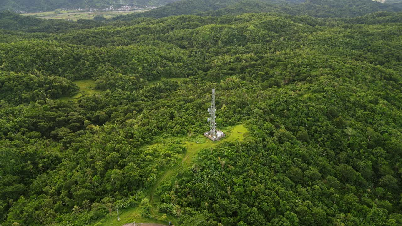 Aerial drone shot of a telecommunications cell tower amid lush tropical island greenery and rolling hills at Catanduanes, Bicol, Philippines