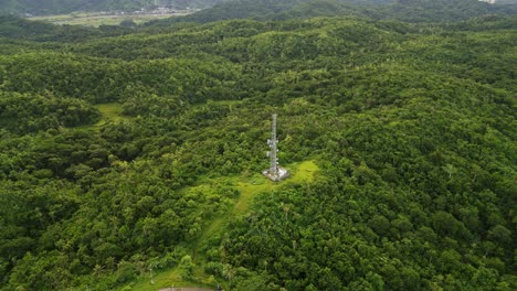 aerial drone shot of a telecommunications cell tower amid lush tropical island greenery and rolling hills at catanduanes, bicol, philippines