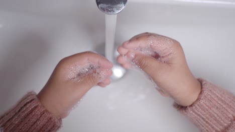 a child washing their hands with soap and water