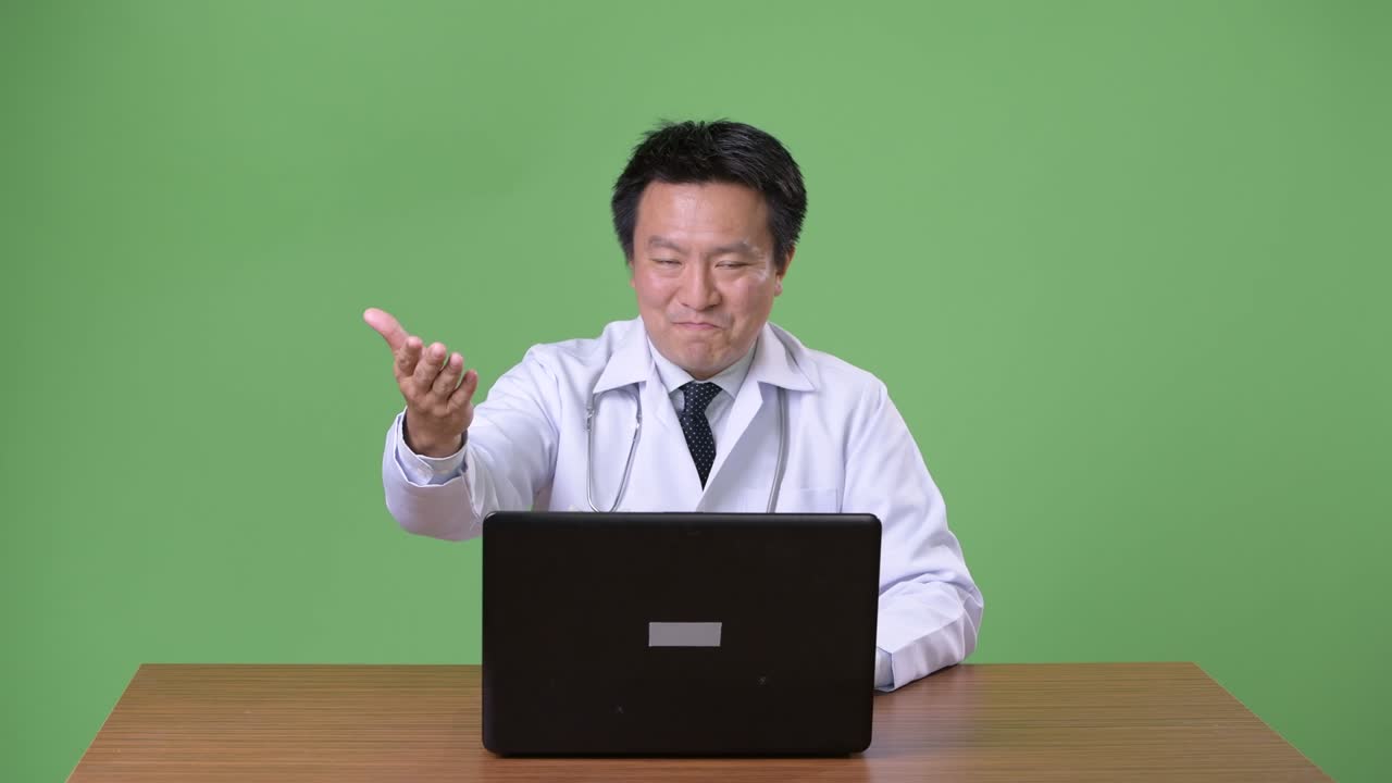 성숙한 일본인 남성, 초록색 배경의 의사