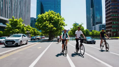 people cycling on a bike path next to a river in a city