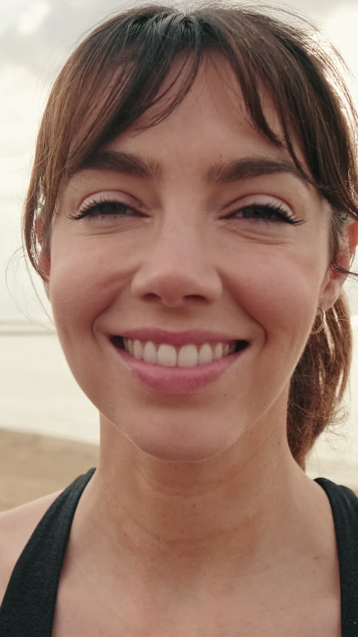 Close-up de Jovem Mulher Feliz Sorrindo ao Ar Livre à Beira-Mar