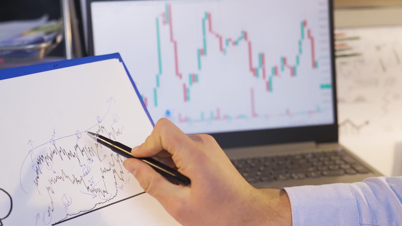 Trader looking at digital and drawn stock market charts.