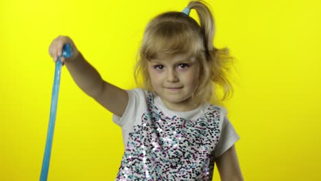 kid playing with hand made toy slime. child having fun making turquoise slime. funny pupil girl