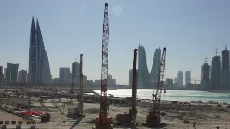 timelapse: construction site in bahrain with city skyline on the background. camera pan.