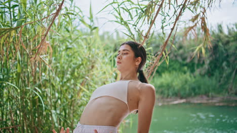 woman performer dancing hands on sunny lake nature closeup. girl bending body