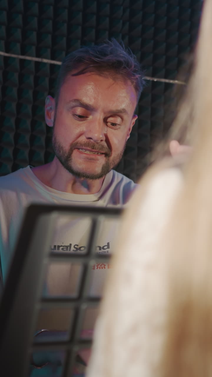 el padre apoya el canto del niño en la escuela. el instructor vocal canta junto con la estudiante durante la sesión vocal. el niño dotado en el estudio de grabación de audio