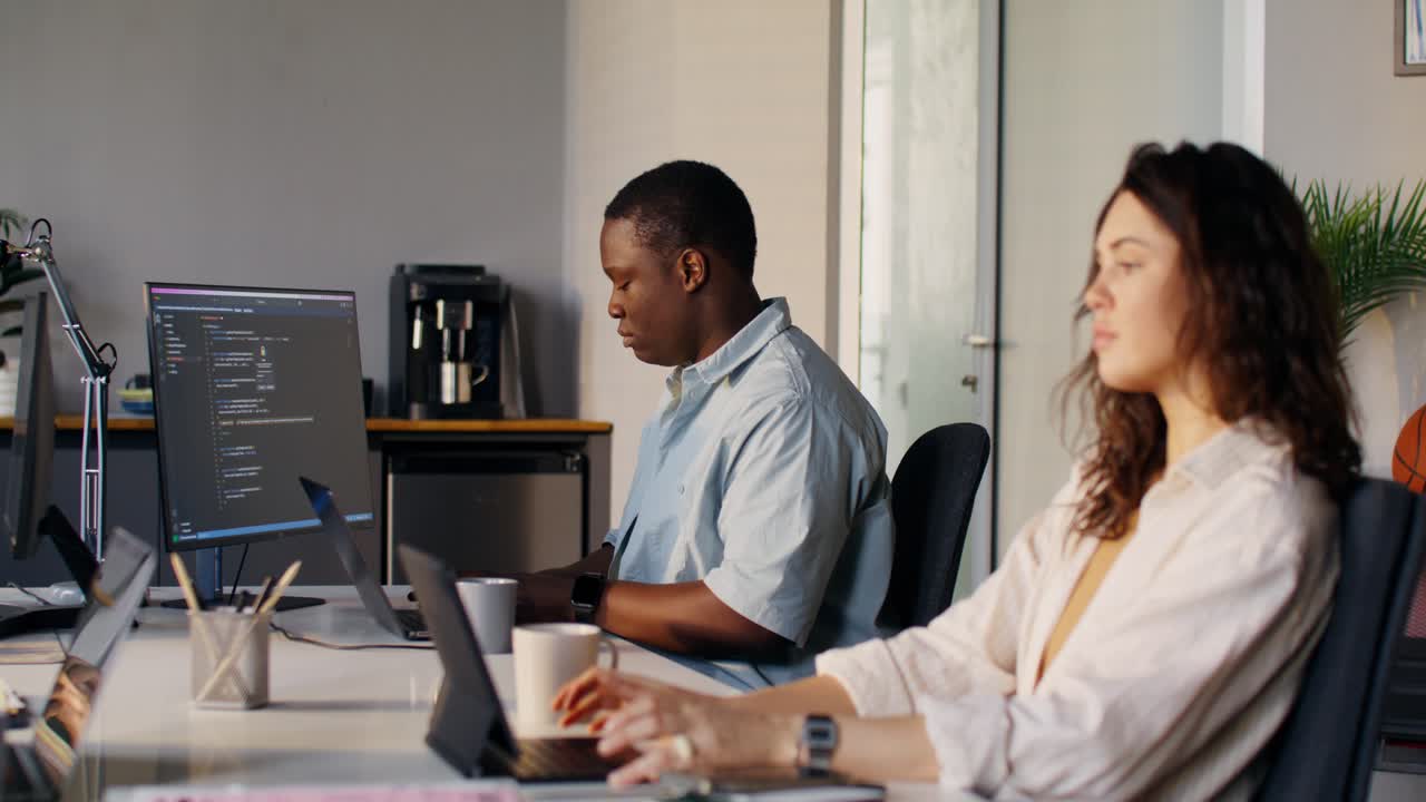 Two People Working on Computers in Modern Office