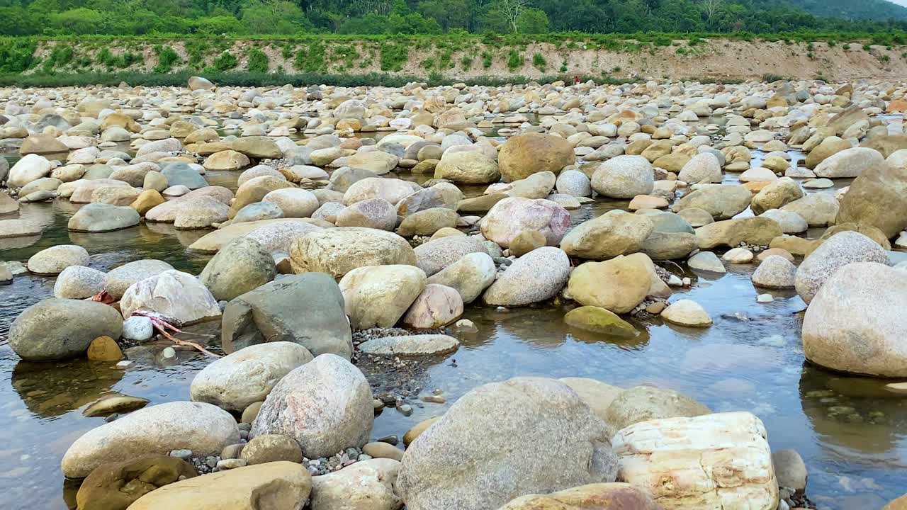 Zoom indietro rivela il letto roccioso del fiume Bichanakandi, Sylhet, Bangladesh, colpito dalla siccità