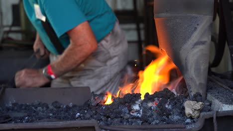 un pequeño fuego caliente en una pequeña forja calentando el metal