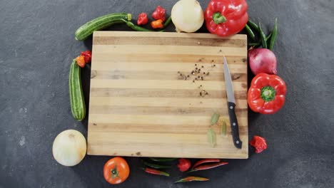 various vegetables arranged around chopping board