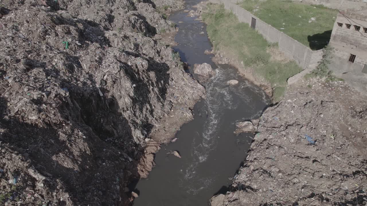 Aerial drone shot of a river flowing next to a dump land fill in Dandora Kenya