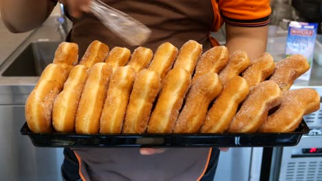 person serving sugar-dusted donuts