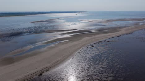 uitgebreid luchtbeeld van een rustig strand en zandbanken onder helder daglicht