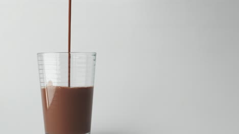 pouring chocolate milk into a glass