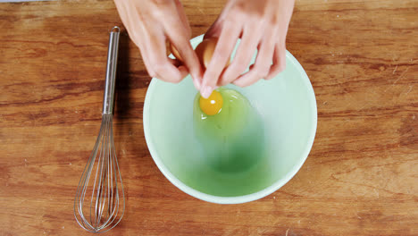 woman breaking eggs in bowl 4k