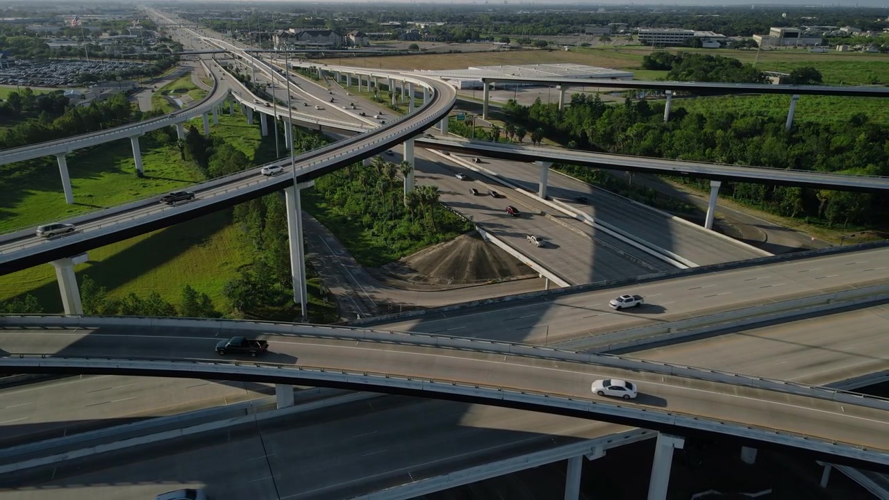 Rekaman Drone Persimpangan Jalan Raya I45 dan Jalan Tol Sam Houston Beltway 8 dengan lalu lintas mobil di sekitar taman pedesaan hijau Texas, AS. Rekaman udara persimpangan jalan raya I45 dan Beltway 8
