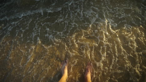 feet in the shallow water on the beach