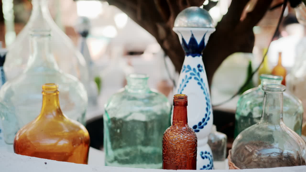 Colorful vintage glass bottles and decanters illuminated by soft sunlight outdoors