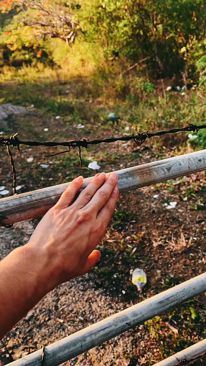 Hand on a Fence in a Natural Setting