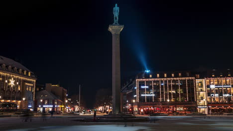 gente caminando por la plaza de la ciudad de trondheim durante la noche mostrando la estatua de oláv tryggvason en el centro de la ciudad.