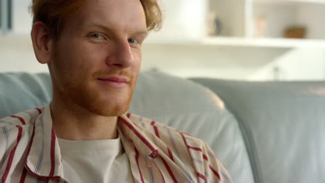 Smiling-guy-resting-alone-on-weekend-closeup.-Pensive-ginger-man-enjoy-morning