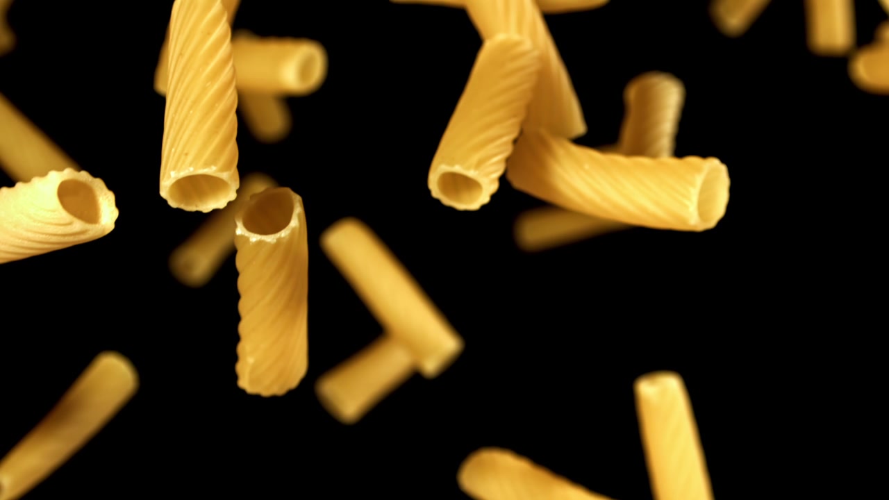 Pasta secca che cade al rallentatore su sfondo nero