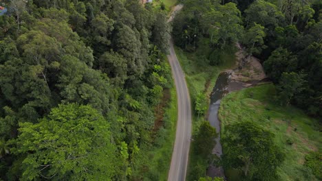 Largo-Camino-Asfaltado-Entre-La-Vegetación-Verde-Del-Valle-De-Currumbin-En-El-Interior-De-La-Costa-Dorada-Del-Sureste-De-Queensland,-Australia